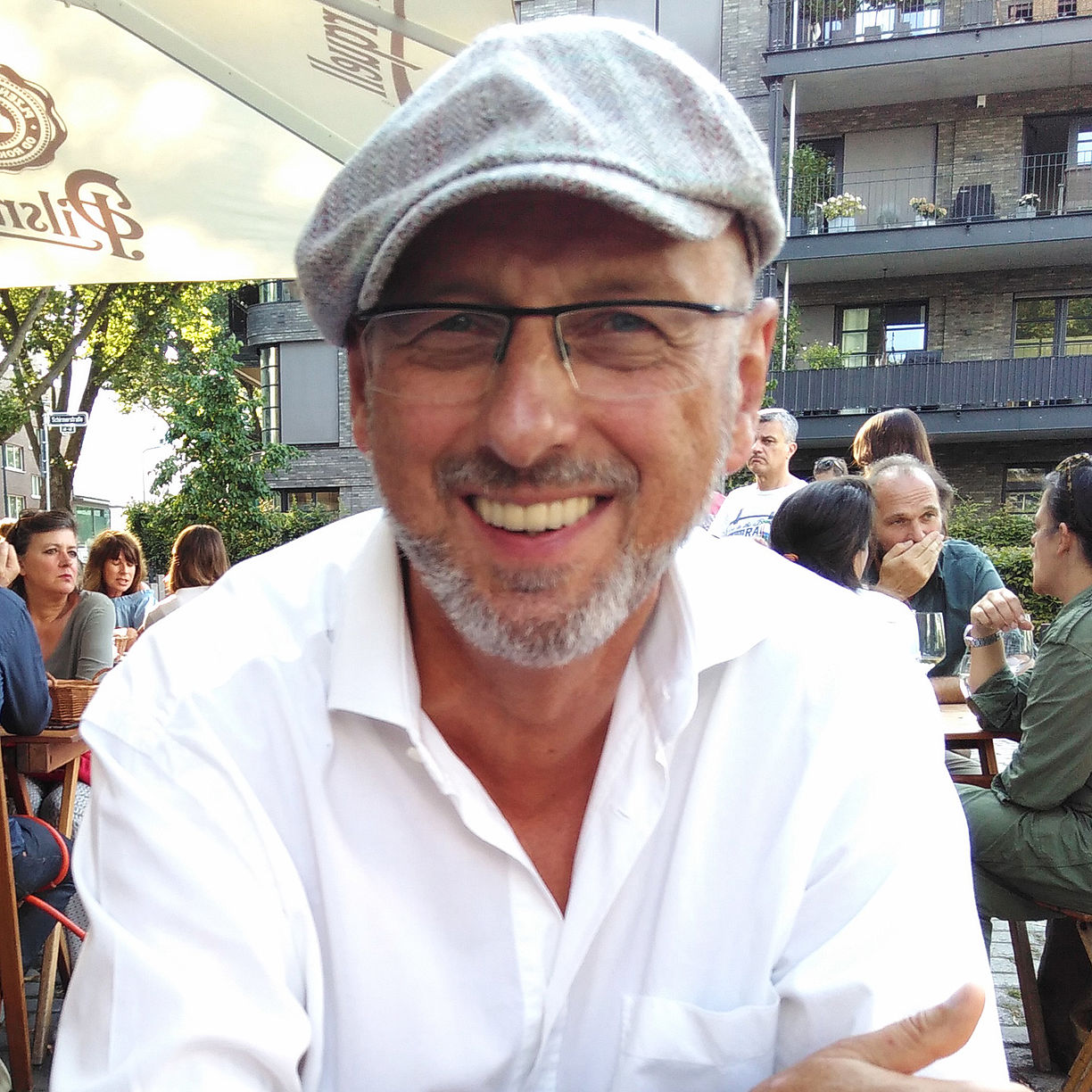 Herr Peter Plaumann glücklich lächelnd im Café